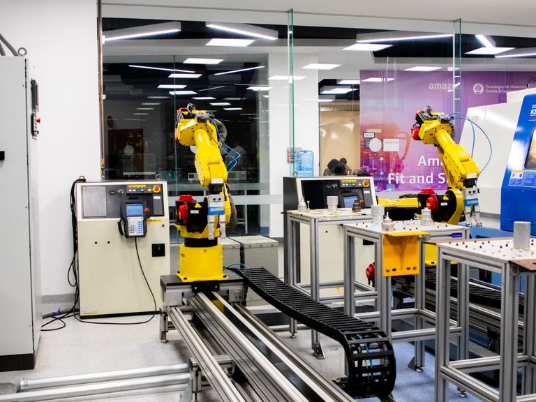 Brazos robóticos en acción en una sala de control industrial moderna